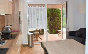 a kitchen and living room with a sliding glass door at L'Orangeraie du Cap in Antibes