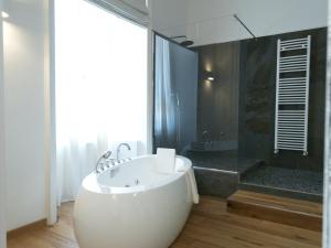 ein Badezimmer mit einer großen Badewanne und einer Dusche in der Unterkunft La Casa delle Tartarughe in Rom