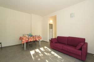 a living room with a red couch and a table at Apartment Pineta 11 in Lido di Pomposa