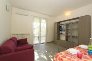a living room with a purple couch and a table at Apartment Pineta 11 in Lido di Pomposa
