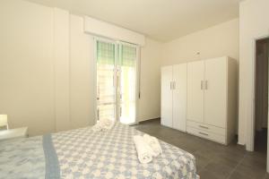 a white bedroom with a bed with towels on it at Apartment Pineta 11 in Lido di Pomposa