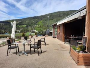 eine Terrasse mit Tischen und Stühlen und ein Gebäude in der Unterkunft L'Inattendu in Le Vernet