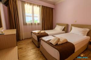 a hotel room with two beds and a window at Villa Arion in Nydri