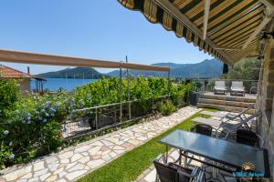 a patio with a table and chairs and a view of the water at Villa Arion in Nydri