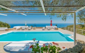 a swimming pool with a view of the ocean at Armyra Villas in Volimes