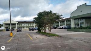 un estacionamiento frente a un gran edificio en Highland Inn Denham Springs Baton Rouge East, en Denham Springs