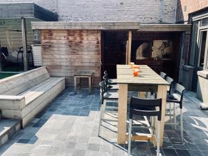 a patio with a table and chairs and a fireplace at De Nachtwaker in Ieper