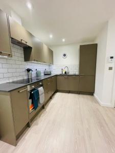 a large kitchen with brown cabinets and a wooden floor at Southernhay Court Apartments by Staytor Accommodation in Exeter