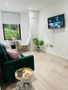 a living room with a green couch and a table at Southernhay Court Apartments by Staytor Accommodation in Exeter