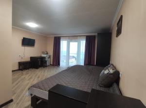 a hotel room with a bed and a television at Гостинний дім "Алмаз" in Kurortne