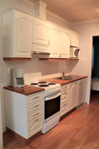 a kitchen with white cabinets and a stove top oven at Rantatähti in Kalajoki