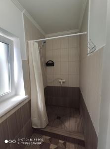 a bathroom with a shower with a shower curtain at Гостинний дім "Алмаз" in Kurortne +33 photos