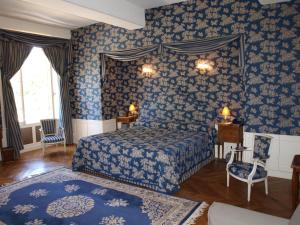 a bedroom with a blue and white striped bedspread at Château de Vault de Lugny in Vault-de-Lugny