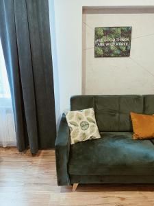 un sofá verde sentado en una sala de estar junto a una ventana en Dworek Zakopane en Zakopane