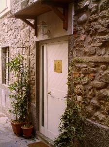 uma porta branca num edifício de pedra com plantas em In Castello em Gallicano