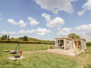 a tiny house with a porch in a field at Malvern View Lodge in Worcester
