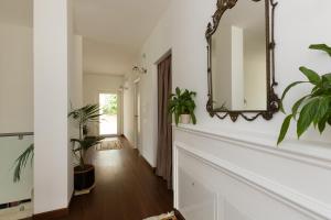 um corredor com plantas e um espelho na parede em B&B Terra del Sole em Valmontone