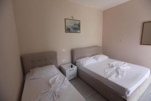 two beds in a small room with white walls at White Hotel in Borsh