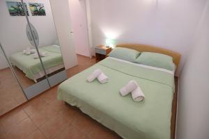 a bedroom with a bed with two slippers on it at Rose Apartment in Zadar