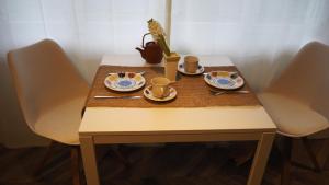 einen Tisch mit Teller, Tassen und Untertassen darauf in der Unterkunft Chalet Tannegg in Reichenbach