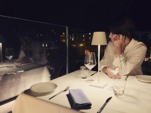 a woman sitting at a table with wine glasses at Hotel Villa Durrueli Resort & Spa in Ischia