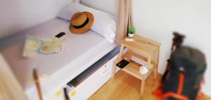 a model of a bedroom with a hat on a bed at Albergue Nacama hostel Pontevedra in Pontevedra