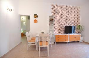 una sala da pranzo con tavolo e TV di Rose Apartment a Zara (Zadar)