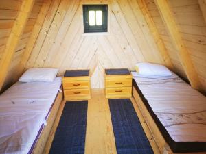 two beds in a wooden cabin with a window at Glamping MM in Muta