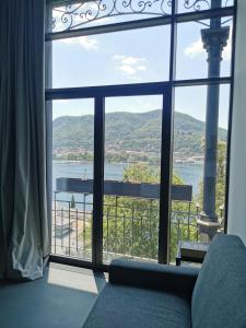 a room with a large window looking out at the water at Veranda lake view in Como