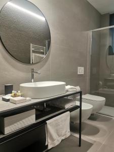 a bathroom with a sink and a toilet and a mirror at Veranda lake view in Como