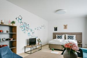 Jarila Boutique Apartment في براتيسلافا: غرفة معيشة مع سرير وتلفزيون