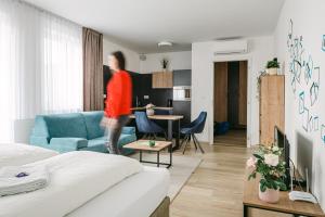a woman is walking through a room with a bedroom at Jarila Boutique Apartment in Bratislava