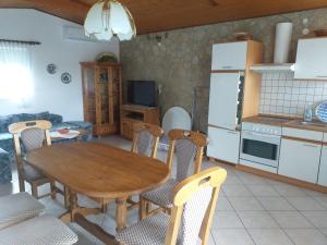 a kitchen and dining room with a wooden table and chairs at Fenyves Villa in Balatonfenyves