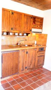 eine Küche mit Holzschränken und einem Waschbecken in der Unterkunft Chalet Tannegg in Reichenbach