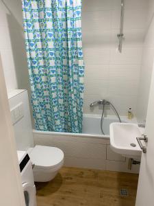 a bathroom with a toilet and a shower curtain at Apartment Azzurro lux in Novi Beograd