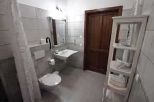 a bathroom with a toilet and a sink and a mirror at A tornácos panzió in Kéthely