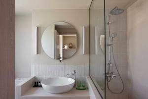 a bathroom with a tub, sink and mirror at Yayaki Spetses in Spetses