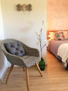 a wicker chair in a room with a bed and a bedroom at D João Xavier Guesthouse in Lagos