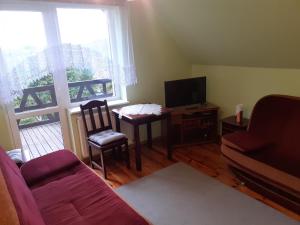 uma sala de estar com um sofá, uma mesa e uma televisão em U Ewy i Grzesia em Krzeszna