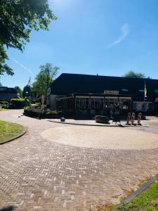 a building with a brick driveway in front of it at 't Zwanemeer in Gieten