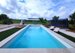 a swimming pool with chairs and a trampoline at Trullo Cicerone in Martina Franca