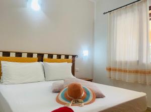 1 dormitorio con 1 cama con sombrero en Sa Murta Bianca Guesthouse, en Budoni