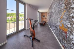 a gym with a treadmill and a wall with windows at Karls Hotel in Sigmaringen