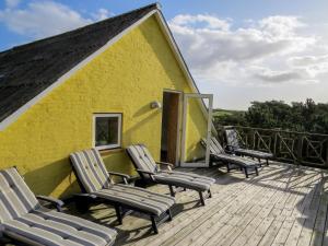 een groep stoelen op het terras van een geel gebouw bij Mandøgården in Ribe