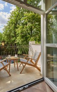 eine abgeschirmte Veranda mit einem Stuhl und einem Tisch in der Unterkunft Villa Antonina in Sopot