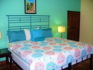 a bedroom with a large bed with a floral bedspread at La Cumbre del Pinar Grupo de Alojamiento Turístico in Valle de Ángeles