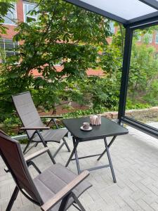 un patio con 2 sillas, una mesa y una mesa con sillas en Möwenhaus, en Emden