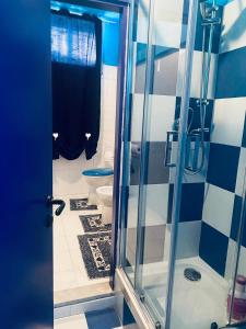 a bathroom with a toilet and a glass shower door at Tremiti Home in Termoli