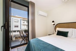 ein Schlafzimmer mit Bett und Blick auf einen Balkon in der Unterkunft Feel Porto Corporate Housing Campanhã in Porto