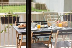einen Tisch mit Speisen und Getränken auf dem Balkon in der Unterkunft Feel Porto Corporate Housing Campanhã in Porto